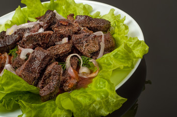 Pork meat grilled with fresh vegetable salad on a white plate. a top view of. Black gradient background