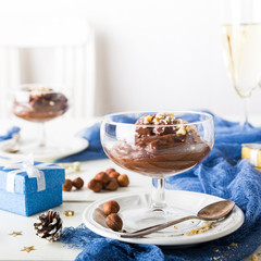 Chocolate pudding mousse with avocado, nuts and holiday decorations. Delicious Christmas themed dinner table.