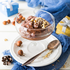 Chocolate pudding mousse with avocado, nuts and holiday decorations. Delicious Christmas themed dinner table.