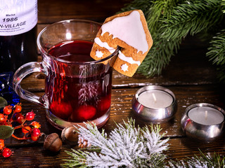 Top view mug of hot alcohol beverage and tasty cookie in house form decoration drink. Winter hot drink. Hot mulled wine with cookie.