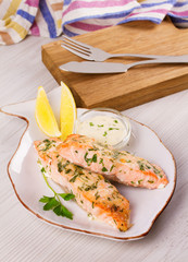Baked salmon with parmesan and herbs, lemon and sauce.