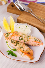 Baked salmon with parmesan and herbs, lemon and sauce.