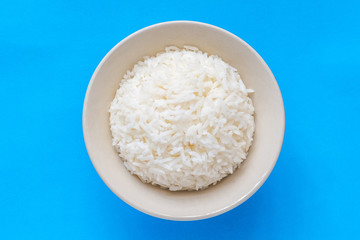 Top view rice in white bowl on blue background