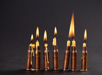Burning candles and empty rifle cartridges.