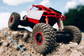 Close-up of toy crawler riding through rocks. Rc car roading on mountain landscape, handmade rally. Racing, extreme, entertainment, competitions concept