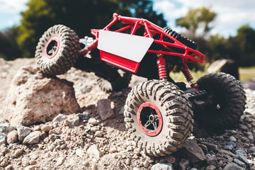 Toy crawler overcoming rock close-up. Rc offroad car riding rocky landscape. Buggy, rally, leisure,...