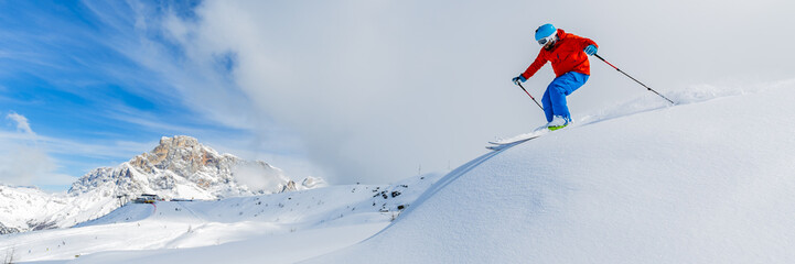 Fototapeta na wymiar Skier skiing downhill in high mountains in fresh powder snow. Sa