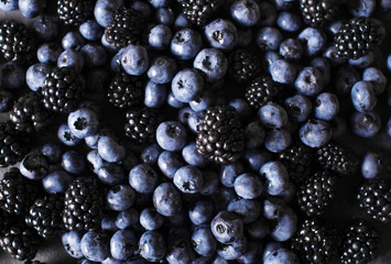 Blackberries, blueberries a gray abstract background. Copyspace. Healthy food concept.  Colorful...