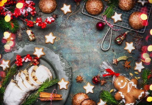 Christmas Baking Sweet Food Frame  With Homemade Gingerbread Man, Cookies, Stollen With Spices , Fir Branches And Red Holiday Decoration On Dark Rustic Background, Top View