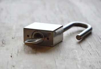 padlock unlocked on wooden board