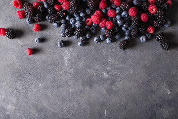 Raspberries, blackberries, blueberries a gray abstract background. Copyspace. Healthy food concept....