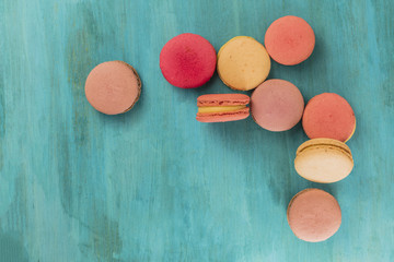 Various macarons on vibrant blue texture with copyspace