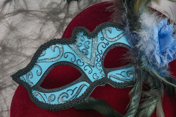 Blue carnival mask with feathers on the red velvet heart