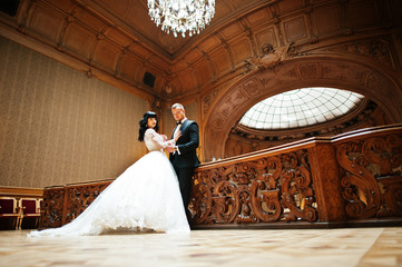 Obraz na płótnie Canvas Magnificent wedding pair newlywed at rich wooden royal palace.