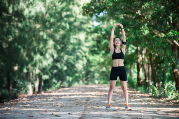 Young fitness woman stretching legs before run.
