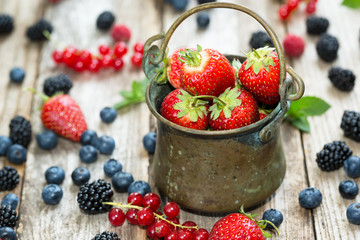 Close-up of strawberries in an antic pail on rustic table full w