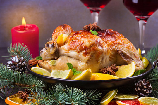 Festive Christmas turkey baked with orange, lemon and lime. Glasses of red wine and candles
