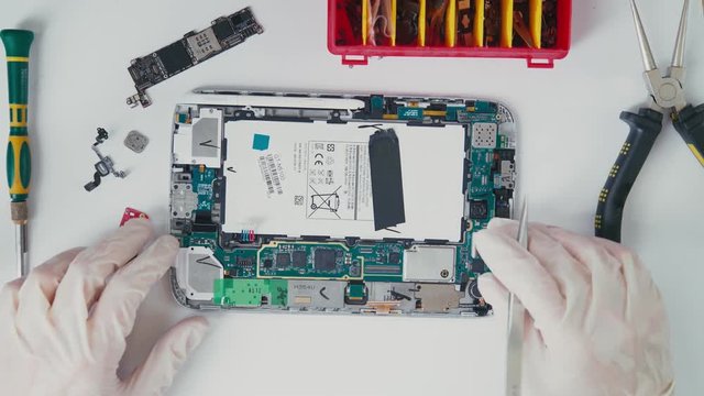 The interior of the tablet device. Repair Wizard tablets made out of mini-tablet. Chip on a printed circuit board. View from the top: the internal structure of the tablet PC. CPU.