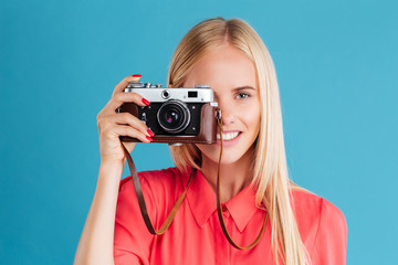 Portrait of a smiling young blonde girl holding photo camera