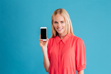 Fototapeta premium Portrait of a happy casual woman showing blank smartphone screen