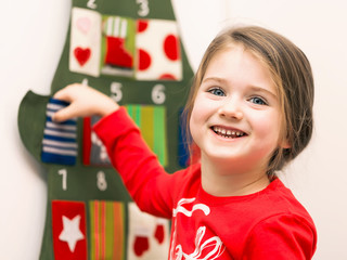 Portrait of a smiling little girl putting her hand into pocket o