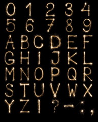 English Letters from sparklers, alphabet and numbers on black background.