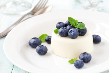 Delicious Italian dessert Panna Cotta with fresh blueberries on a white plate