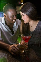 Couple looking at each other and smiling while having drinks