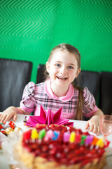 Close-up portrait of a little girl widely smiling in front of bi