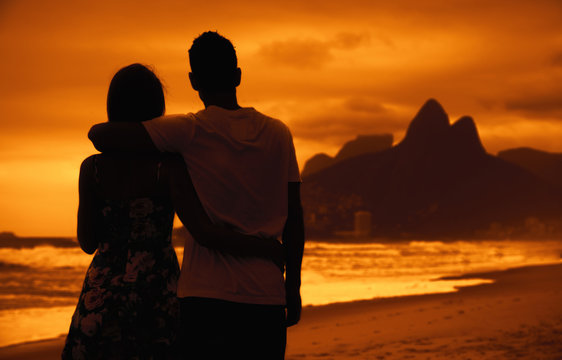 Love couple in arms on beach at sunset at Rio de Janeiro