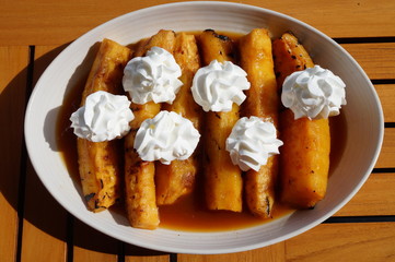Slices of roasted caramelized pineapple with whipped cream