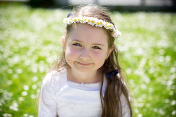 Close-up portrait of a beautiful little girl with a flower wreat