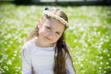 Close-up portrait of a cute girl with daisy wreath