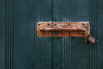 Old rusted lock on a wooden door or shutters. Mediterranean door