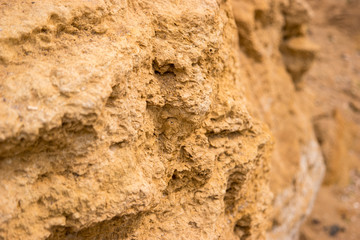 Texture of yellow rock. Light colored stone. Nature builds might. Material for geological studies.