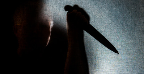 A man with a knife in the backlight