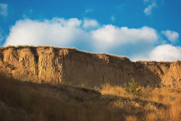 Sandy cliff and sky. High dry grass. Become one with nature. Search for inspiration.