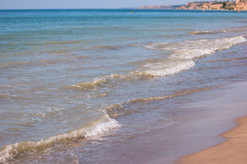 Little waves on seashore. Water, sand and horizon. Wonderful spot for summer vacation. Sunbathe the whole day.