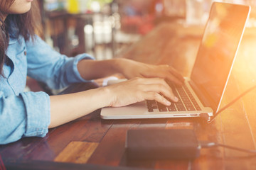 Young business woman working on laptop computer while sitting in