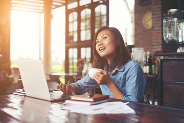 Obraz premium Beautiful hipster woman using laptop at cafe while drinking coff
