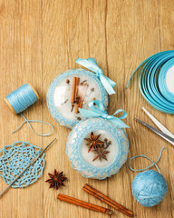 Fototapeta na wymiar White beautiful Christmas balls decorated with a blue knitted pattern on wooden background, top with view copy space