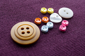 Cute sewing buttons man. Funny character with love white heart button. violet textile background. macro view