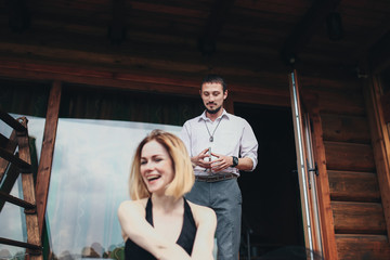 Beautiful stylish couple rest near the house