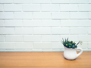 flowerpot on table with white brick wall