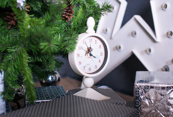 New Year's clocks under a fir-tree. Christmas concept. gifts under a fir-tree © monoliza