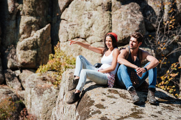 Couple taking a break after hiking uphill and pointing finger