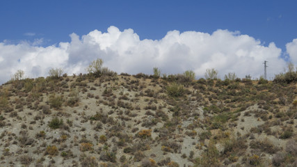 Clouds behind hill