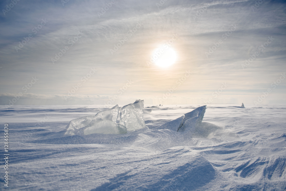 Wall mural boundless icy landscape during a snowstorm at sunset in winter.