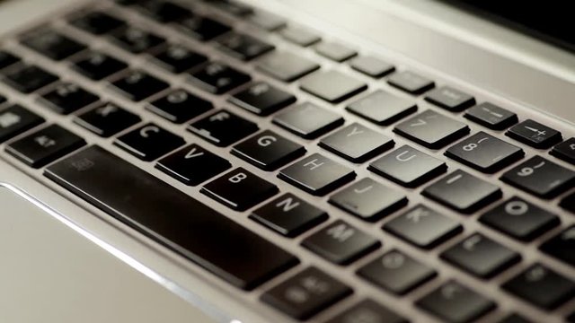 Panning close up footage of a laptop keyboard.