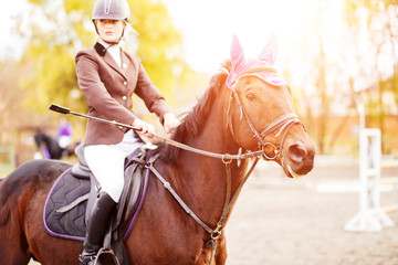 Fototapeta premium Young rider woman riding horse at the competition
